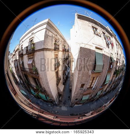 Fish eye view deep within the Gothic Quarter the old city of Barcelona Spain with its typical narrow alleyways and high apartment blocks.