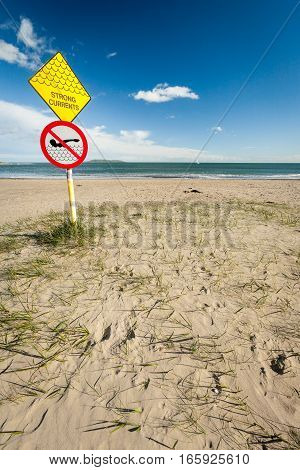 A sign at a sandy beach near Malahide Ireland warning people of the strong currents expected in the nearby waters.