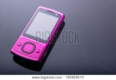 Old pink mobile phone on gradient background