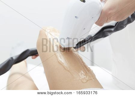 Beautician Giving Epilation Laser Treatment To Woman On Thigh