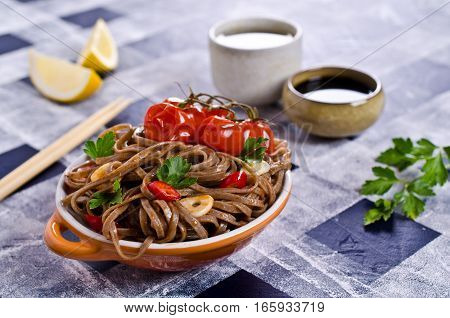 Buckwheat noodles with vegetables in a spicy sauce. Selective focus.