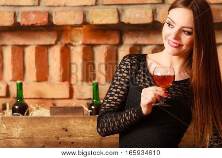 Woman Tasting Wine In Rural Cottage Interior