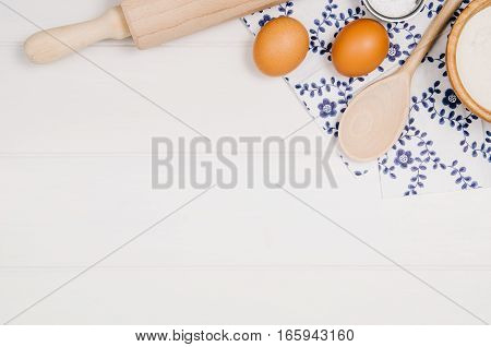 Baking a cake or pizza ingredients background. Top view photograph with kitchen utensils on vintage, natural, white, wooden background.