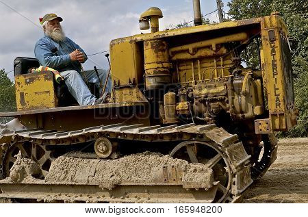 ROLLAG, MINNESOTA, Sept 1. 2016: The unknown bearded operator of a Vintage Caterpillar is  being driven at the West Central Steam Threshers Reunion in Rollag, MN attended by 1000's held annually on Labor Day weekend.