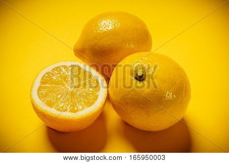 some delicious and fresh lemons on a yellow background