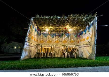 Fabric sukkah decorated with printed pattern and hebrew text of blessing: Grant peace everywhere goodness and blessing Grace lovingkindness and mercy to us and unto all Israel Your people. Night
