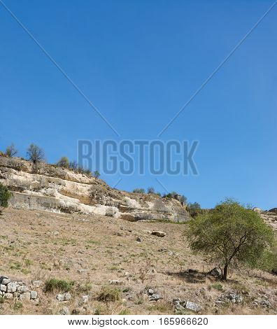 View of the cliffs of the city-fortress Chufut-Kale from the beam Maryam-Dere in the early autumn
