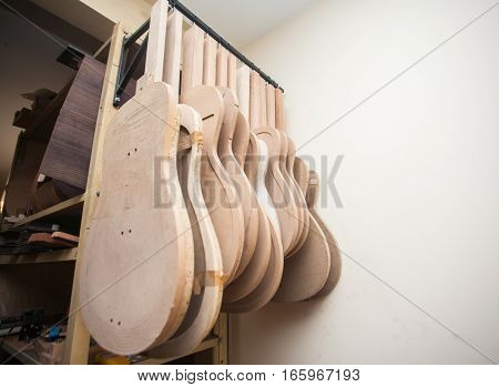 a row of classical unfinished guitar at workshop.