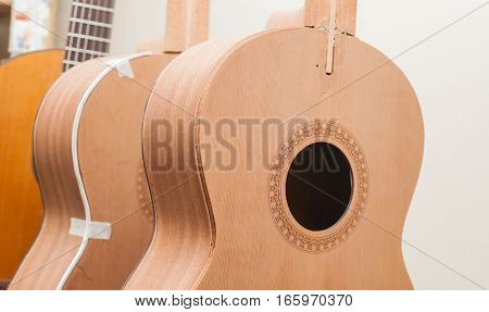 a row of classical unfinished guitar at workshop.