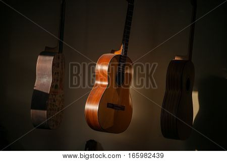 a row of classical unfinished guitar at workshop in sunlight.
