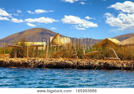 Manmade floating island with a sign spelling out Titikaka on Lake Titicaca in Peru