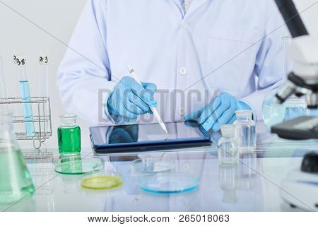 Laboratory Worker Entering Information About Medical Reseach In Tablet Computer