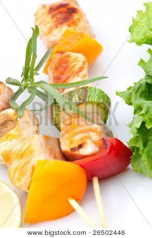 Nærbillede af grillet laks og vegetabilske spyd med frisk estragon og grøn salat