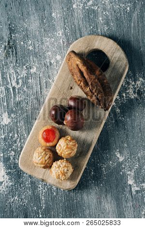 high angle view of some chestnuts, some panellets and a roasted sweet potato, as a typical snack eaten in All Saints Day in Catalonia, Spain, called castanada