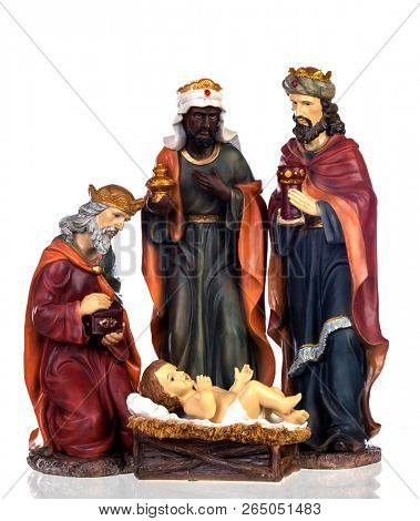 The three wise men and baby Jesus. Ceramic figures isolated on white background