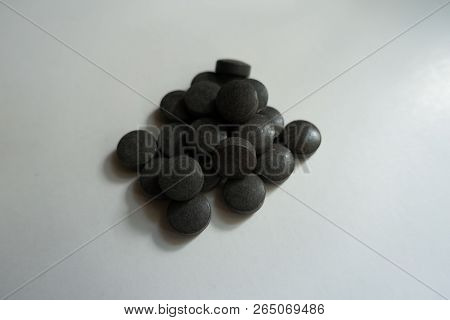 Black Pills Of Chelated Iron In A Heap