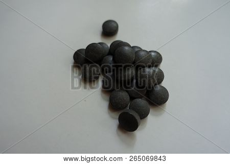 Dark Grey Pills Of Chelated Iron In A Heap