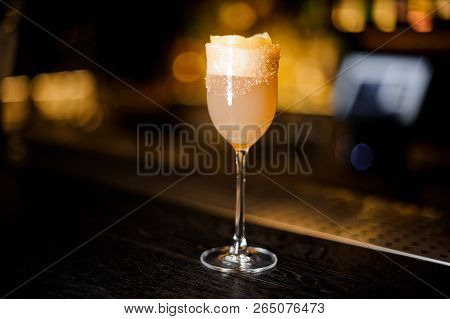 Elegant Sweet Wine Glass Filled With Delicious Brandy Crusta Cocktail On The Bar Counter Against Dar