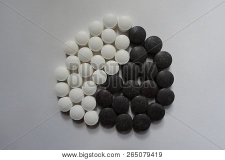 Yin And Yang Symbol Formed Of Black And White Round Pills