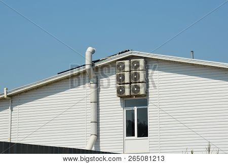 Ventilation Systen On Siding House Construction With Air Compresors And Chimney.