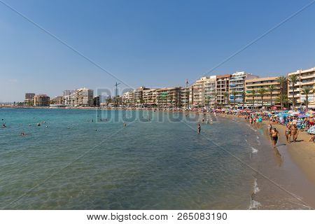 TORREVIEJA, SPAIN-OCTOBER 6th 2018: A busy beach with tourists and holidaymakers in the beautiful Sp