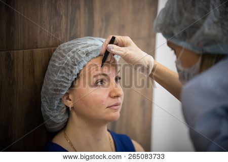 Woman In A Cosmetology Clinic. Specialist Scatching On Client Face