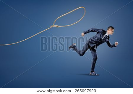 A Businessman In A Suit Runs Away From A Rope Lasso That Tries To Catch Him.