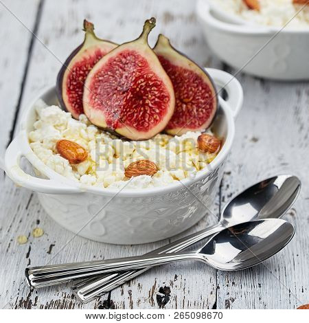 Cottage Cheese With Figs And Almonds In A White Bowl On A Light Background. Concept: Healthy Breakfa