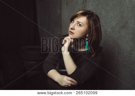 Vintage Portrait Of Beautiful Stylish Pensive Girl With Turquoise Earrings On Gray Studio Background