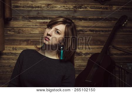 Vintage Portrait Of Beautiful Stylish Girl With Turquoise Earrings In Old Wooden Hut.