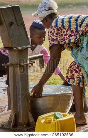 Ghana, Accra - January 02, 2017: African Ghana Girl With Her Mum Take Water At The Well In Accra, Gh