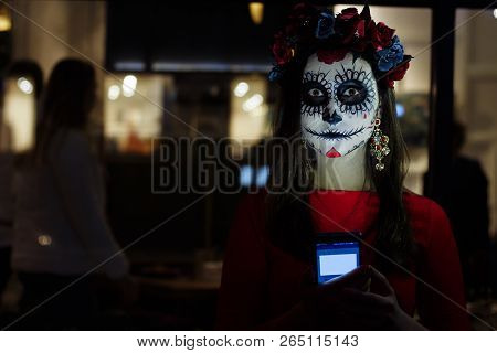 A Girl With A Painted Face Of A Skeleton, A Dead Zombie, In The City During The Day. Day Of All Soul