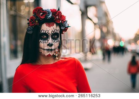 A Girl With A Painted Face Of A Skeleton, A Dead Zombie, In The City During The Day. Day Of All Soul