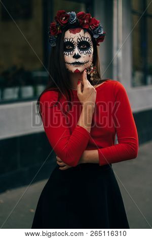 A Girl With A Painted Face Of A Skeleton, A Dead Zombie, In The City During The Day. Day Of All Soul