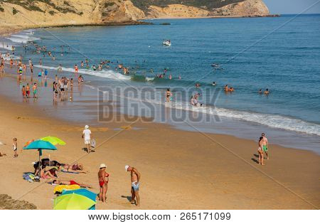 VILA DO BISPO, PORTUGAL - AUGUST 21, 2018: People at the famous beach of Salema in Vila do Bispo. This beach is a part of famous tourist region of Algarve.