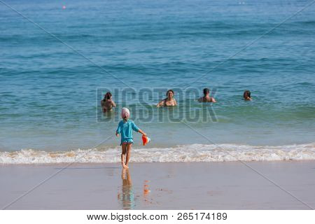 VILA DO BISPO, PORTUGAL - AUGUST 21, 2018: People at the famous beach of Salema in Vila do Bispo. This beach is a part of famous tourist region of Algarve.