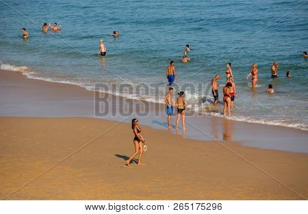 VILA DO BISPO, PORTUGAL - AUGUST 21, 2018: People at the famous beach of Salema in Vila do Bispo. This beach is a part of famous tourist region of Algarve.