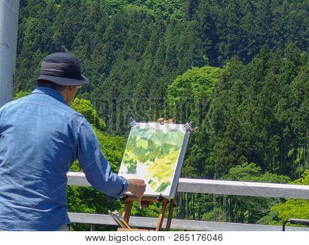 2016 May 05. Tokyo Japan. A Japanese Man Looking And Drawing A Natural Green Forest Background At Mi