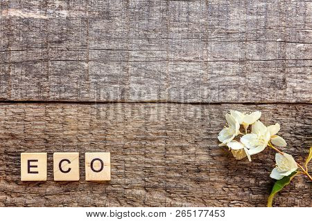 Inscription Eco Letters Word Jasmine Flower On Old Rustic Wooden Backdrop. Eco Village Abstract Envi