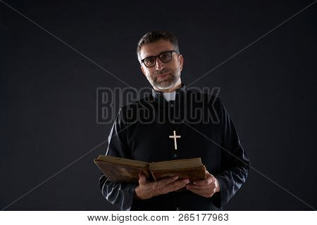 Priest portrait with Holy Bible in hands isolated