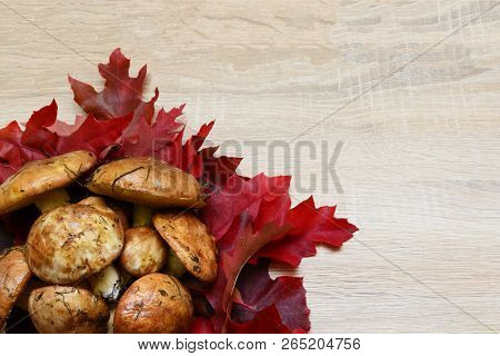 Mushrooms And Leaves On Wooden Table, Autumnal Decorations