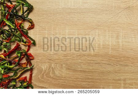 Dry Red And Green Bell Pepper On Wood Background. Space For Text