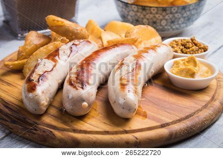 Grilled german sausages with mustard and fried potato chips