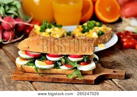 Baguette Sandwich With Egg, Arugula Salad, Tomatoes And Radish