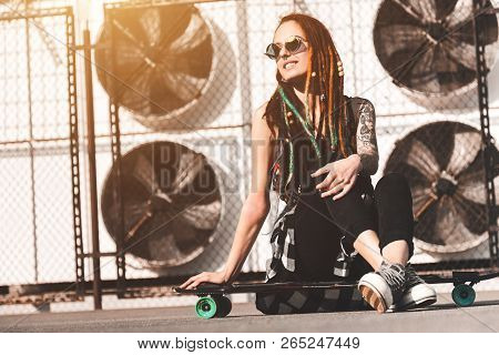 Young Girl With Tattoo And Dreadlocks On Urban Industrial Background