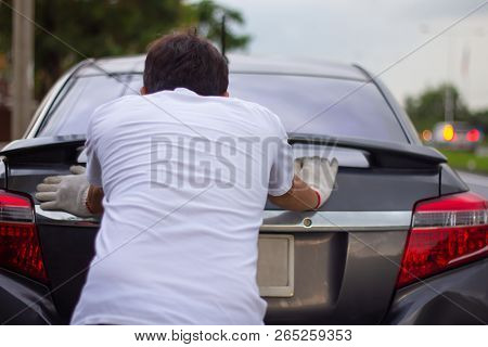 Mechanic Man Pushing A Broken Car Down The Road Back View.
Vehicle Empty Gasoline Petrol.
Accident A