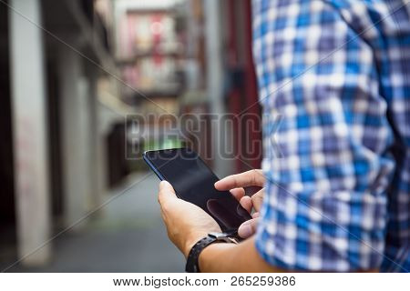 Man Holding, Touching Or Working On Mobile Phone With Blank Black Screen With Copy Space. Male Hands