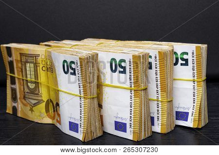 Pile Of 50 Real Euro Notes 50-euro Banknotes Under Rubber Band Isolated On Black. About 20000 Euros 