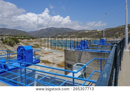 Germasogeia Dam On A Bright Blue Sky Day In Early Summer. Shows The Blue Mechanism For The Overflow 
