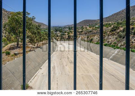 Overflow Of Germasogeia Dam On A Bright Blue Sky Day In Early Summer.   Shot Is Taken Looking Throug